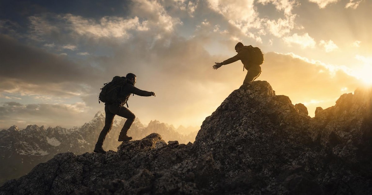 Climbing partners moving toward each other on a ridge, representing pursued intimacy