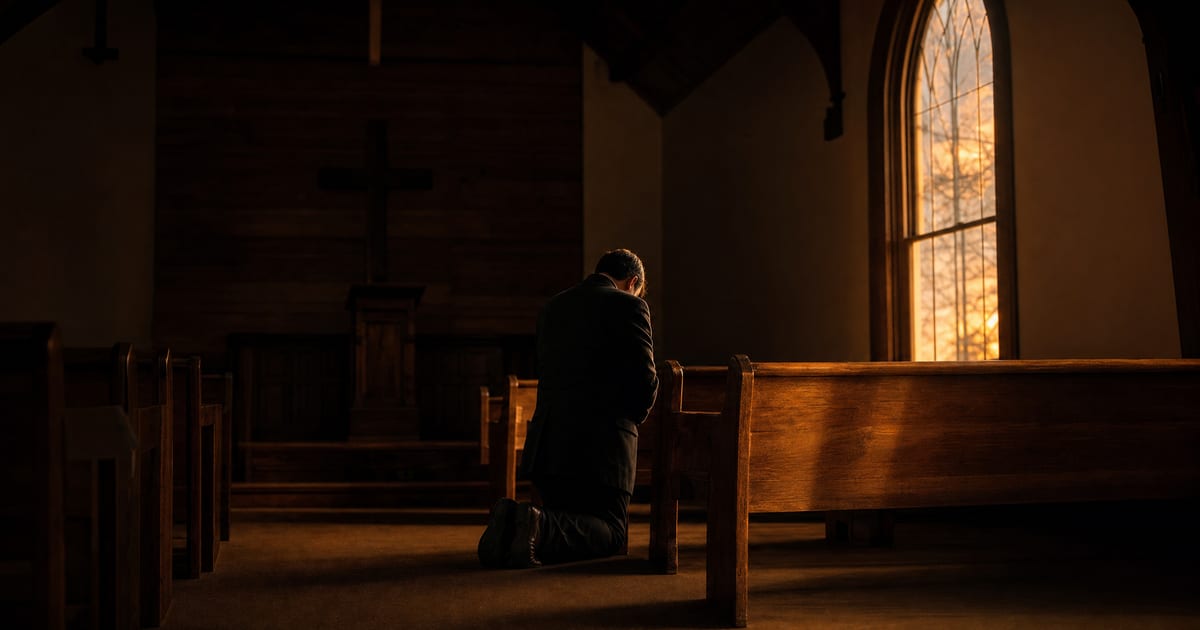 A pastor kneeling alone in prayer in a dim church sanctuary, representing the hidden struggle with pornography many pastors carry in silence