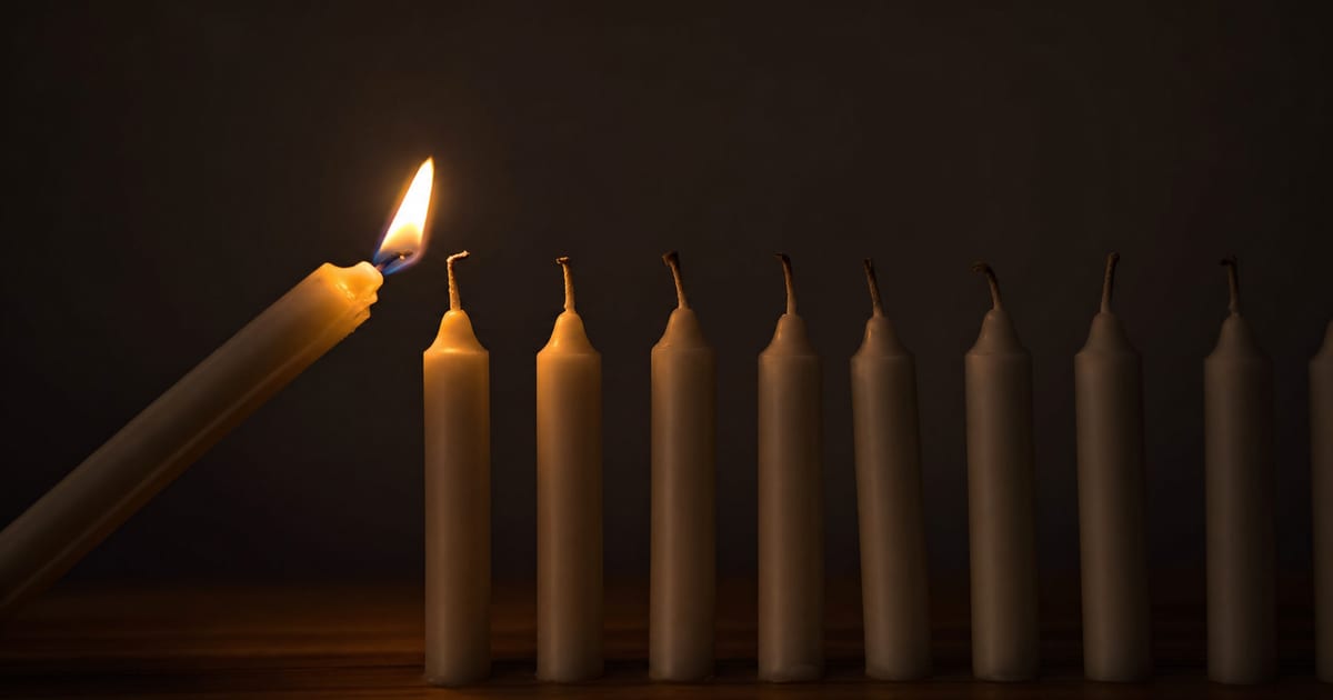 A single lit candle passing its flame to a row of unlit candles, representing who a pastor should tell first about his pornography struggle
